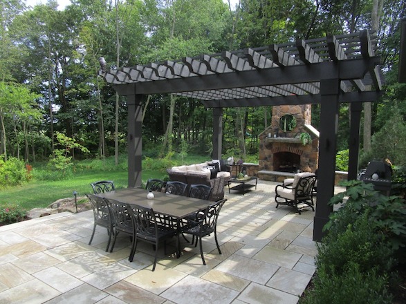 /Content/uploads/A grand pergola dominates the space, juxtaposing beautifully with the light patio stone and complementing the fireplace and home exterior.