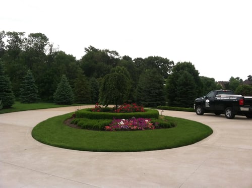 A Northeast Ohio landscape with colorful plantings, decorative containers, landscape lighting and professionally maintained gardens